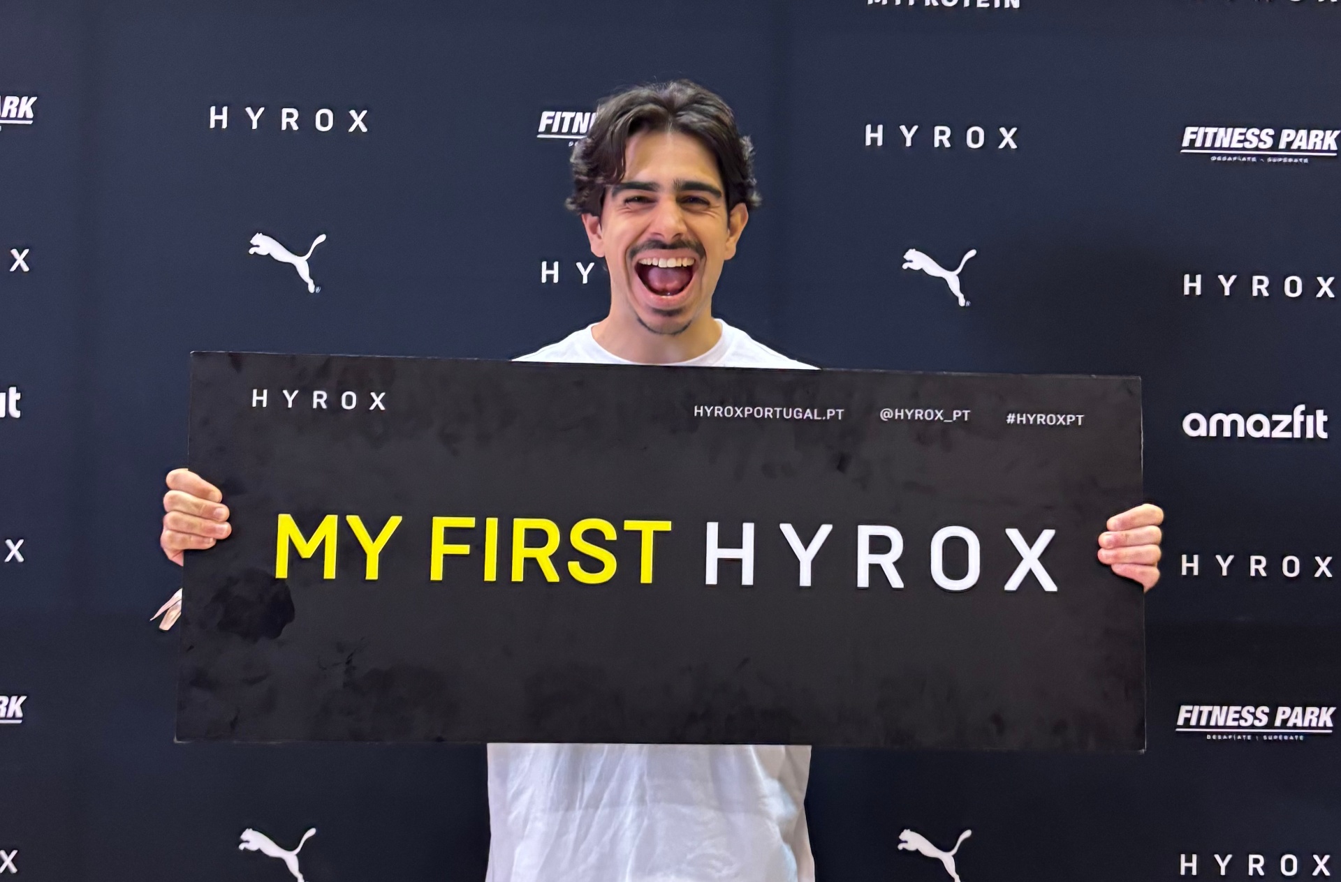 Afonso a segurar uma placa MY FIRST HYROX no backdrop oficial